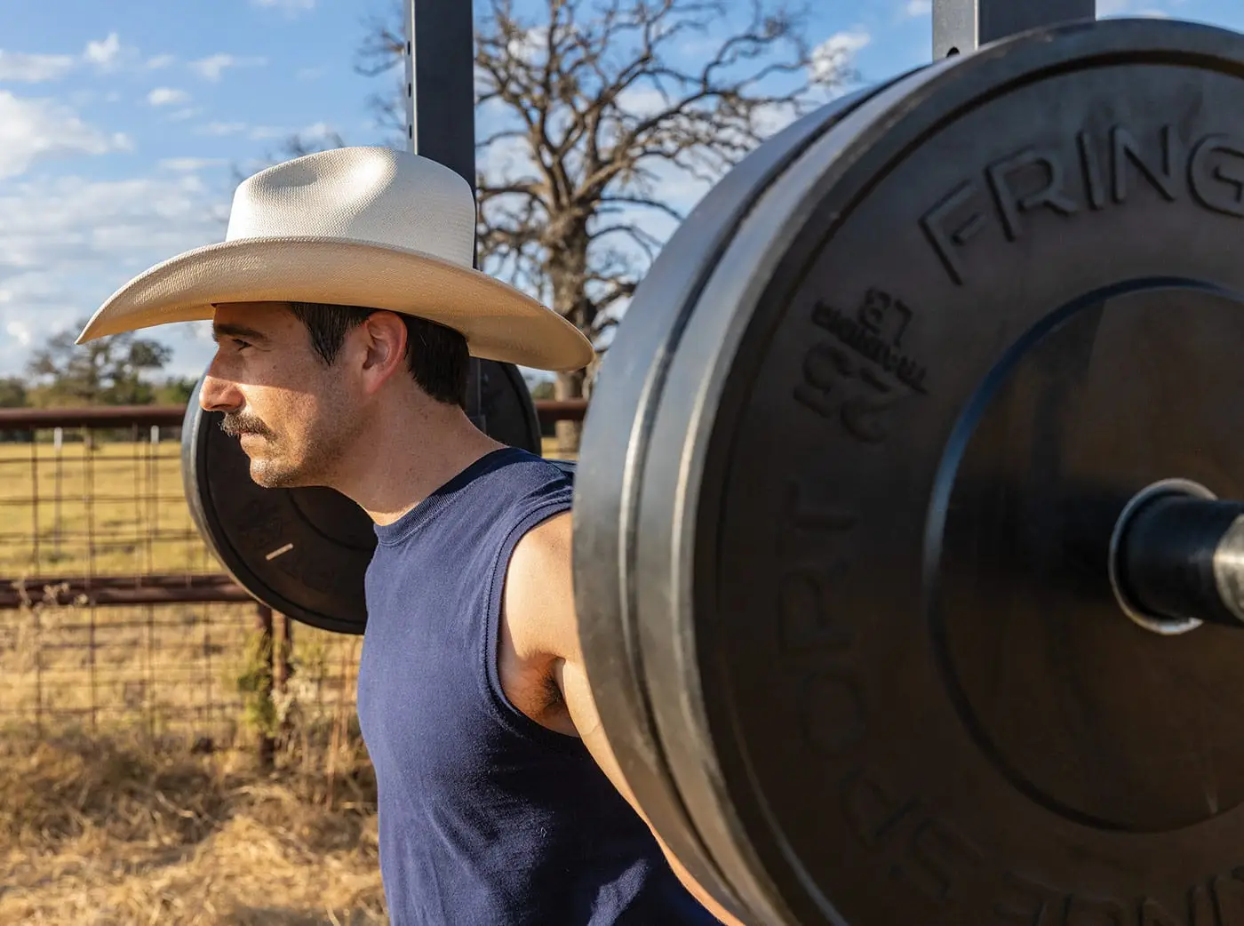 Barbells & Beef Manifesto | Founder Joe Cavazos lifting in a pasture