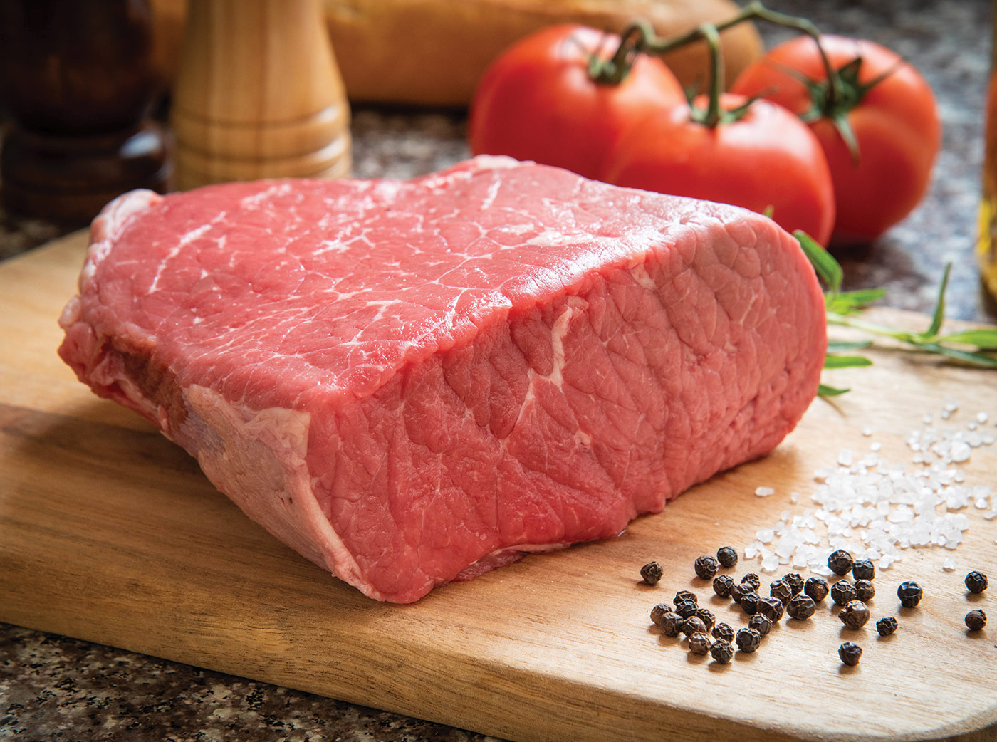 BBNB Cut of the Week | Raw beef bottom round roast on cutting board with peppercorns